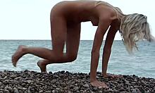Blondýnka pózuje úplně nahá na skalnaté pláži