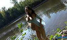 Pregnant bombshell showing her half-naked body by the water