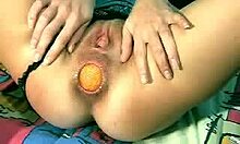 Извращенная шлюха вставляет огромный оранжевый шарик в свою задницу