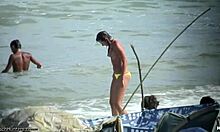 Топлес жена показва гърдите си на нудистки плаж