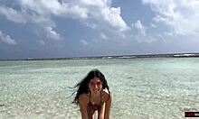 Złoty deszcz na plaży na Malediwach dla pięknej dziewczyny, która sika